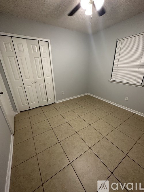 A room with a white door and tiled floor.