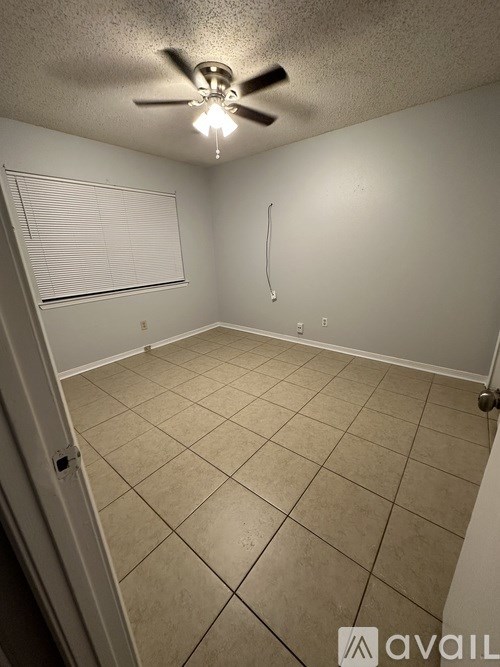 A room with a ceiling fan and a door.