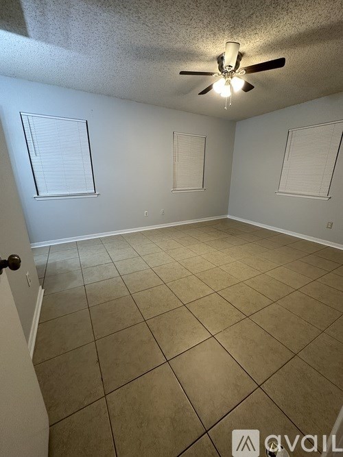 A room with a ceiling fan and tiled floor.