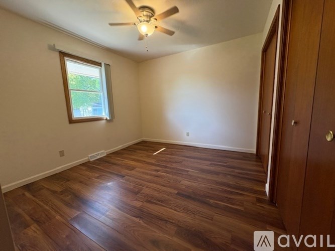 A room with wooden flooring and a ceiling fan.