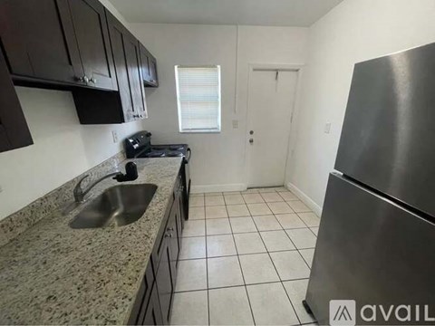 A kitchen with granite countertops and a stainless steel refrigerator.