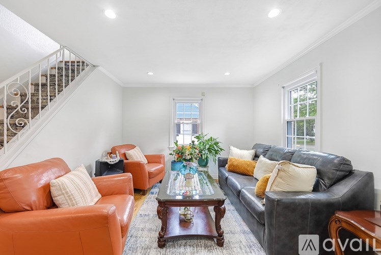 A living room with a staircase and a coffee table.