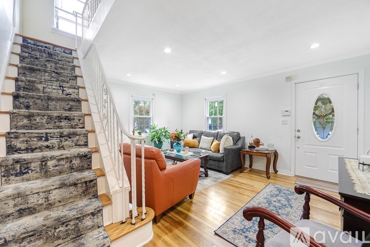 A living room with a staircase and a couch.