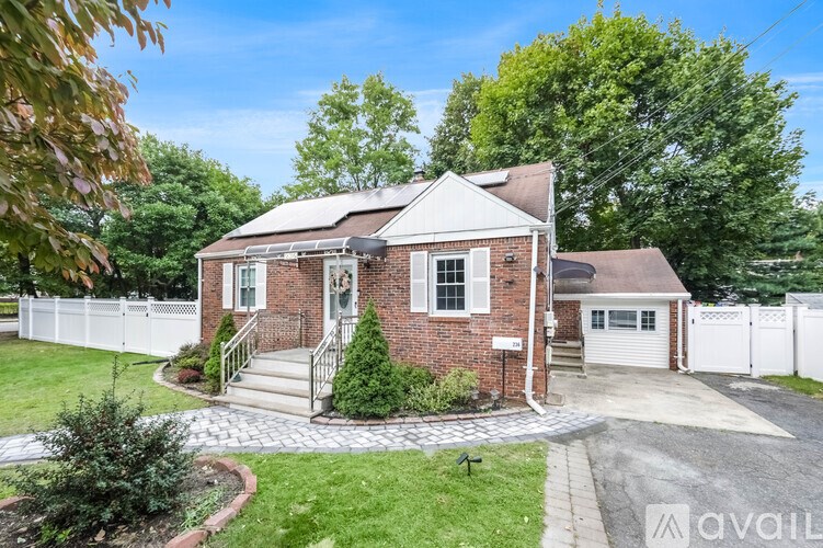 A house with a white picket fence and a brick exterior.