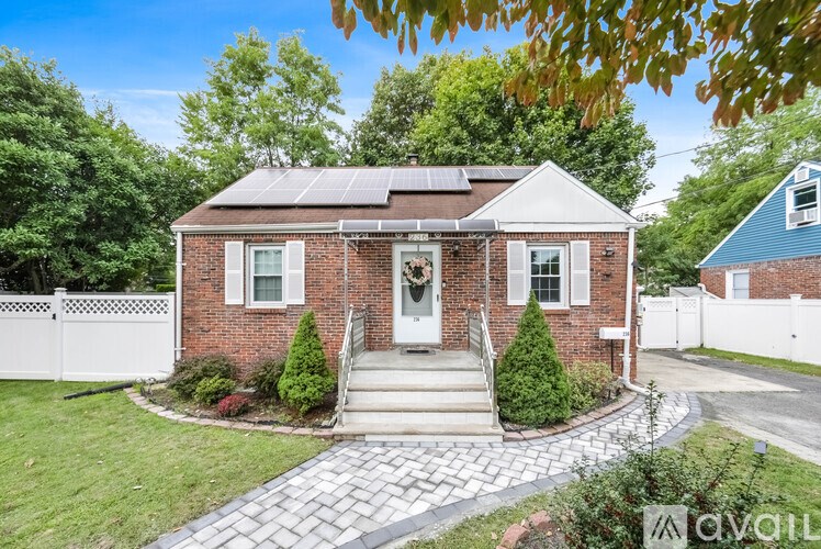 A house with a brick facade and solar panels on the roof is for sale.
