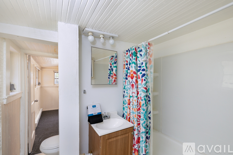 A small bathroom with a toilet, sink, and a mirror.