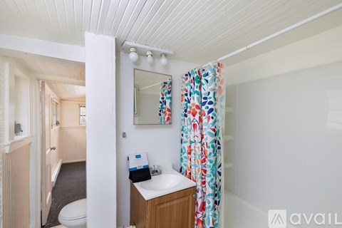 A small bathroom with a toilet, sink, and a mirror.
