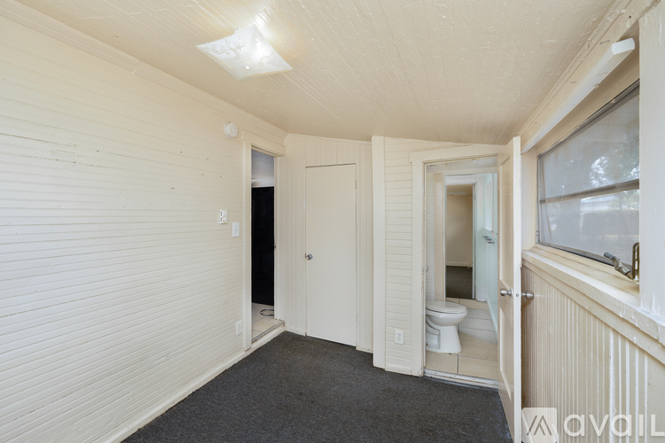 A room with a toilet and a window.