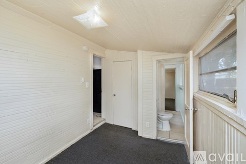 A room with a toilet and a window.