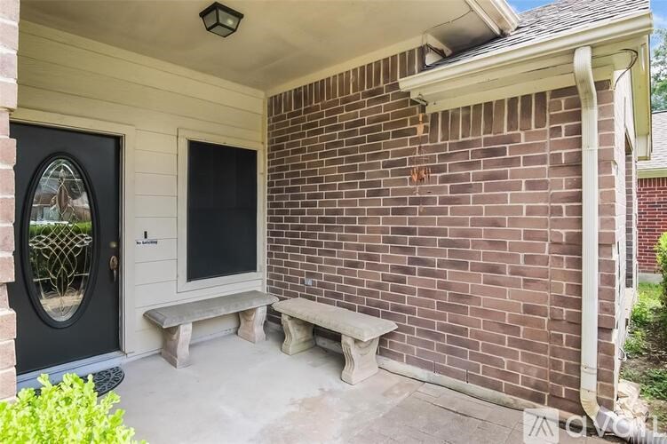 A black door is on the left side of a brick wall.