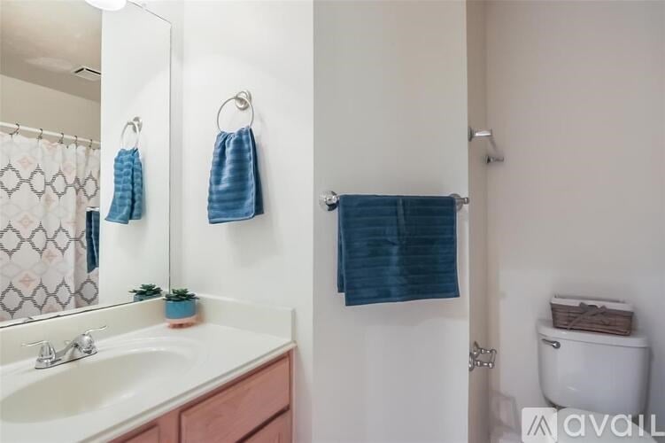 A bathroom with a white sink and a blue towel hanging on the wall.