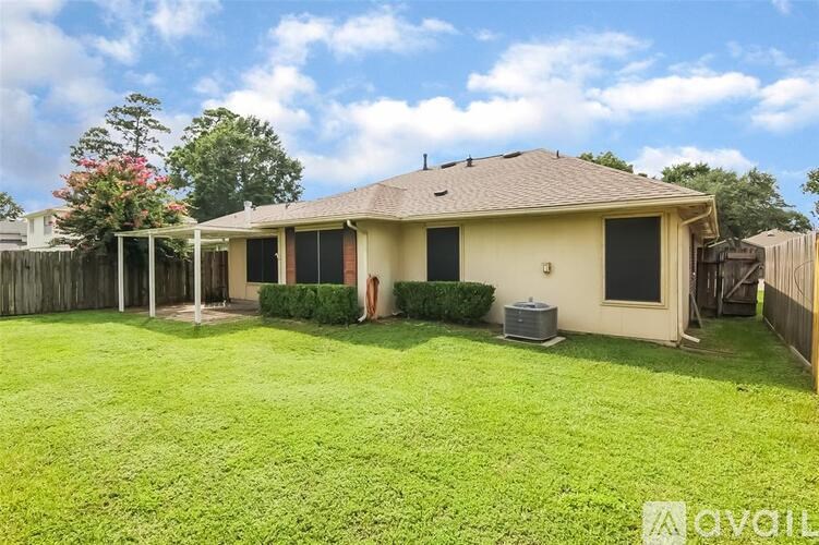 A house with a lawn and a tree in the backyard.
