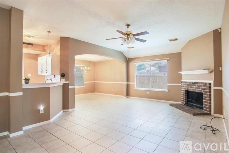 A living room with a fireplace and a ceiling fan.