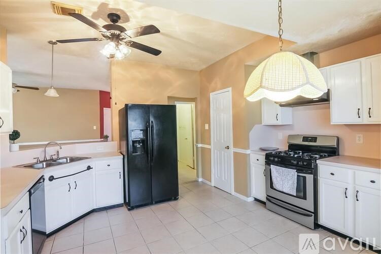 A kitchen with black appliances and white cabinets.
