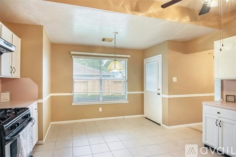 A kitchen with a stove top oven and a fan.