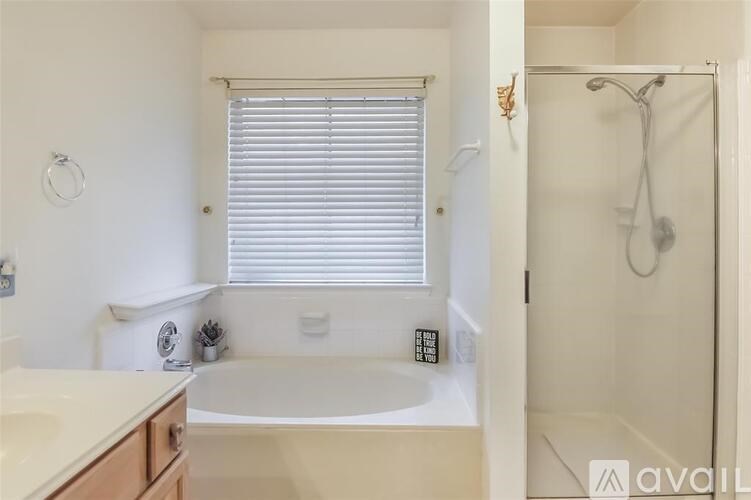 A white bathroom with a tub, sink, and shower.