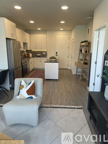A modern kitchen with a white chair and a white table.