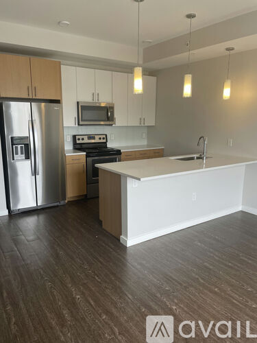 A kitchen with a refrigerator, stove, and microwave.