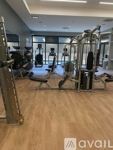 A gym with a variety of equipment including a squat rack, a leg press machine, and a bench press.