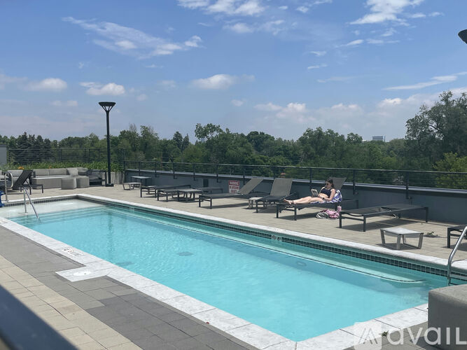 A pool with people relaxing by it.