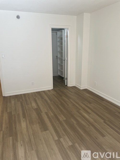 A room with wooden flooring and a white door.