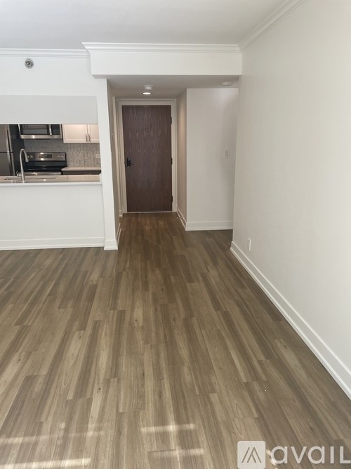 A room with a wooden floor and a brown door.