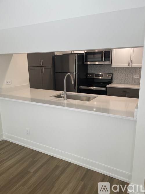 A kitchen with a sink and a refrigerator.