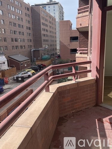 A balcony with a railing overlooking a city street.