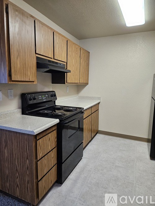 A kitchen with wooden cabinets and black appliances.
