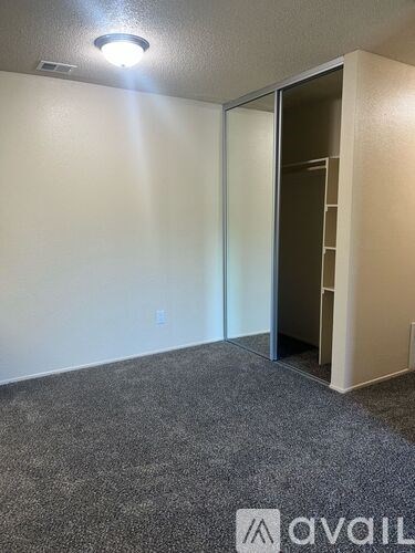 A room with a carpeted floor and a doorway leading to another room.