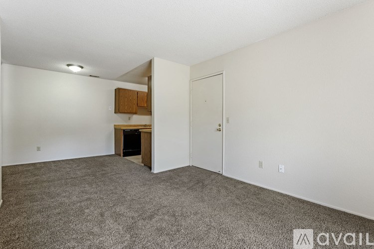 A room with a carpeted floor and a wooden cabinet.