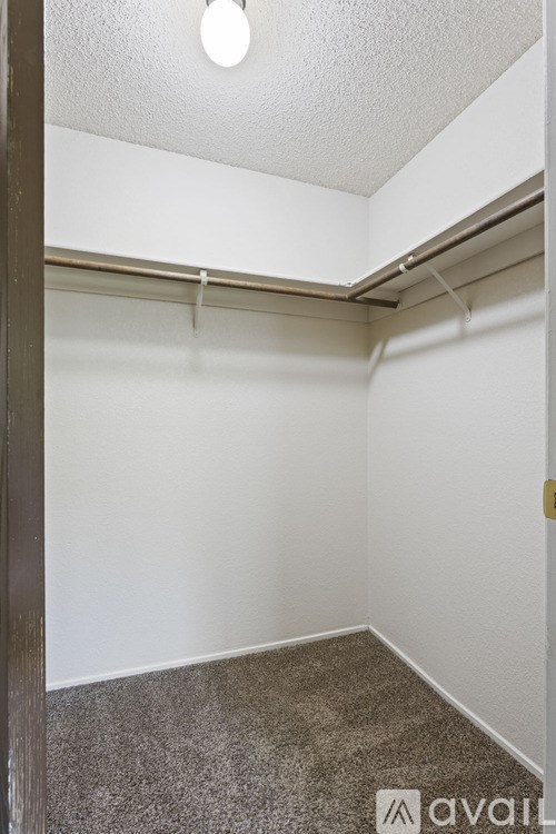 A small, empty room with a grey carpet and white walls.