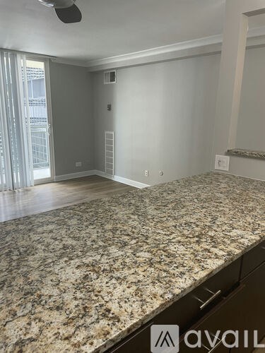 A room with a granite countertop and a fan on the ceiling.