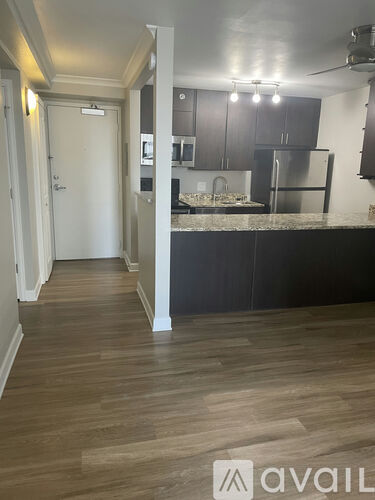 A kitchen with a refrigerator, cabinets, and a countertop.