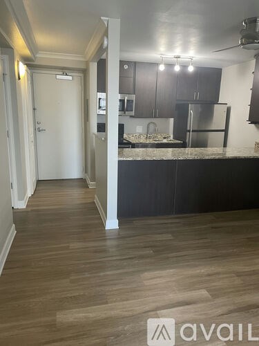 A kitchen with a refrigerator, cabinets, and a countertop.