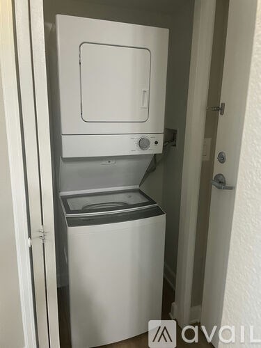 A small white dishwasher is built into a cabinet.