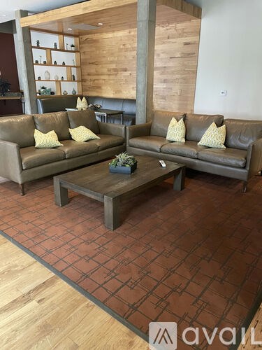 A living room with a brown couch and a coffee table.