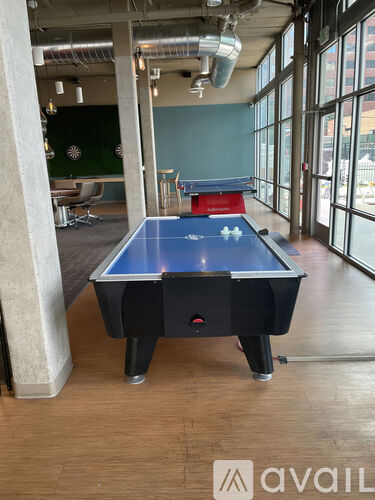 A pool table in a room with a green wall and a window.