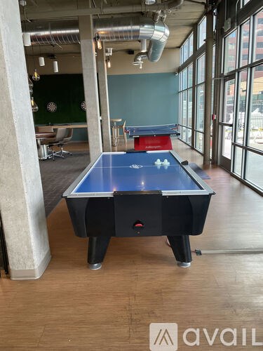 A pool table in a room with a green wall and a window.