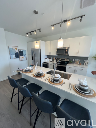 A kitchen with a table set for four with chairs around it.