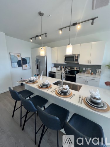 A kitchen with a table set for four with chairs around it.