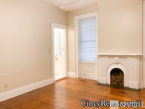 A room with a fireplace and a door leading to another room.