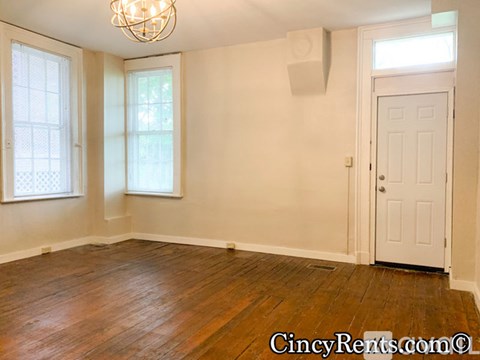 A room with a wooden floor and a white door.