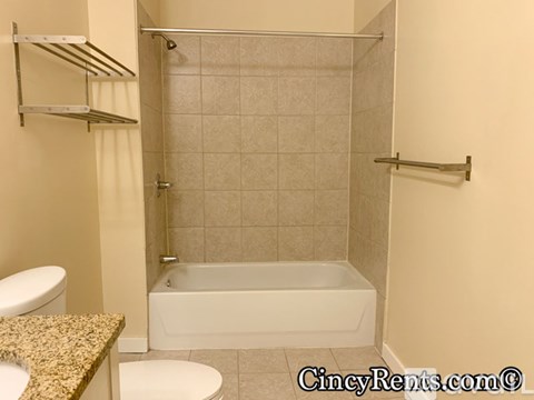 A bathroom with a white tub and toilet.