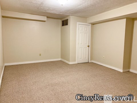 A room with a carpeted floor and a white door.