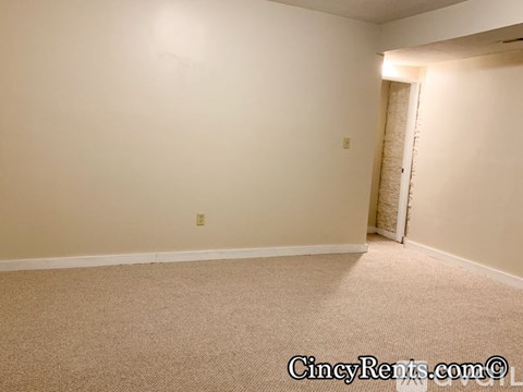 A room with a carpeted floor and a door on the right side.