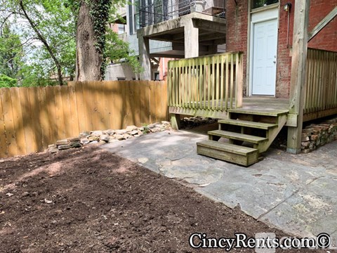 A backyard with a wooden deck and a white door.