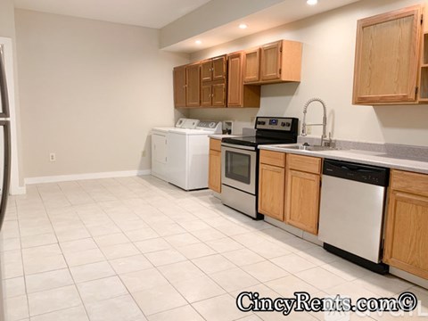 A kitchen with white appliances and wooden cabinets.