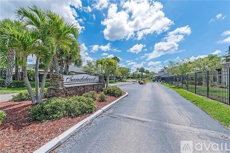 A street view of a residential area with a sign that reads "Sandland".