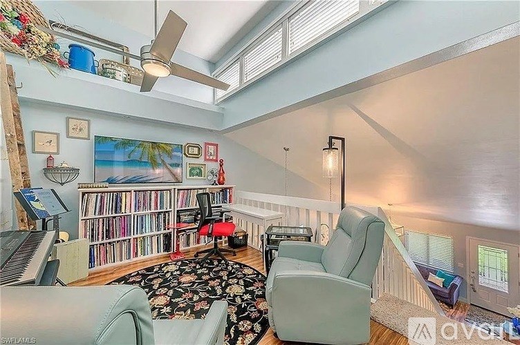 A living room with a piano, a chair, and a ceiling fan.